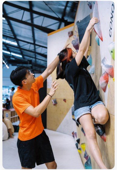 Coach guiding a climber on the wall.